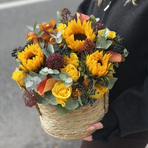 Композиция в сумке "Тональность" из подсолнухов, калл, ягод вибирнума, лимонных роз, скиммии и орхидеи в Звенигороде