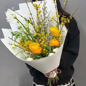 Весенний букет с желтыми ранункулюсами и цветущими ветками форзиции в Звенигороде